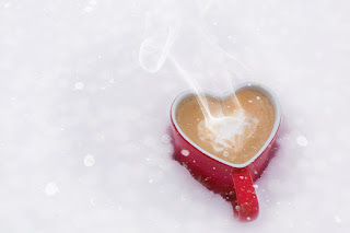 heart shaped mug filled with coffee and creamer