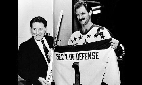 Rod Langway, whose nickname was 'Secretary of Defense', gives a Caps sweater to Secretary of Defense Caspar Weinberger, whose nickname was 'Cap' (Yes, really)