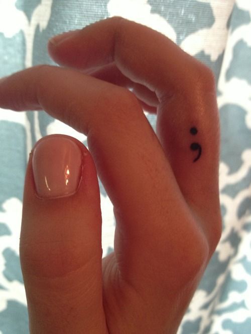 tatuaje de punto y coma en un dedo