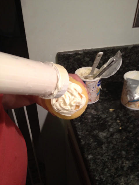 frosting a cupcake with pregnant belly in view