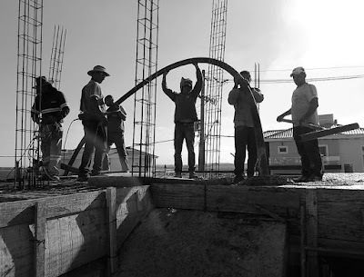 Operários concretam a laje de uma casa em construção (foto: Jean Tosetto).