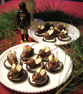 dessert mice made out of maraschino cherries and Hershey Kisses with almond sliver ears sitting on top of an Oreo half