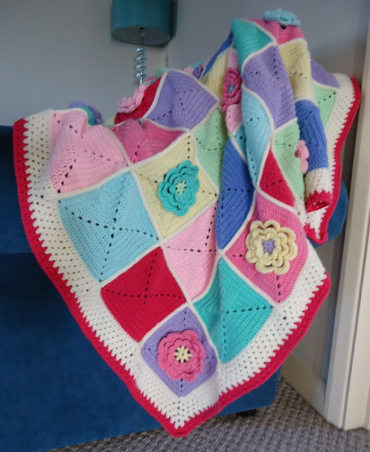A beautiful colourful crochet blanket with a lovely waterlily design - click through for inspiration for a stunning cosy flower crochet blanket.