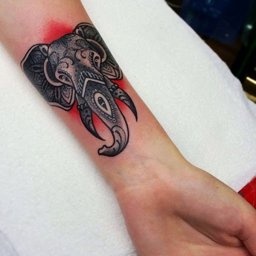 Um elefante retrato é embelezado com mandala elementos e ilustrado sobre um fundo vermelho.