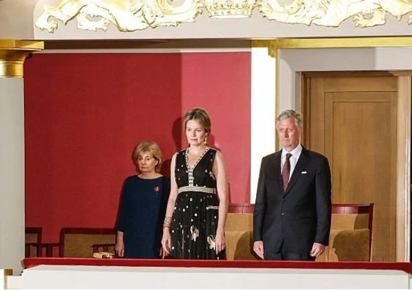 Queen Mathilde at Queen Elisabeth Piano Competition. Queen Mathilde wears Diane Von Furstenberg - DVF Vivanette Embroidered Tulle Goddess Gown. A Bag with a Story Clutch, TIKLI JEWELRY Gold Drop Earrings and Bracelet