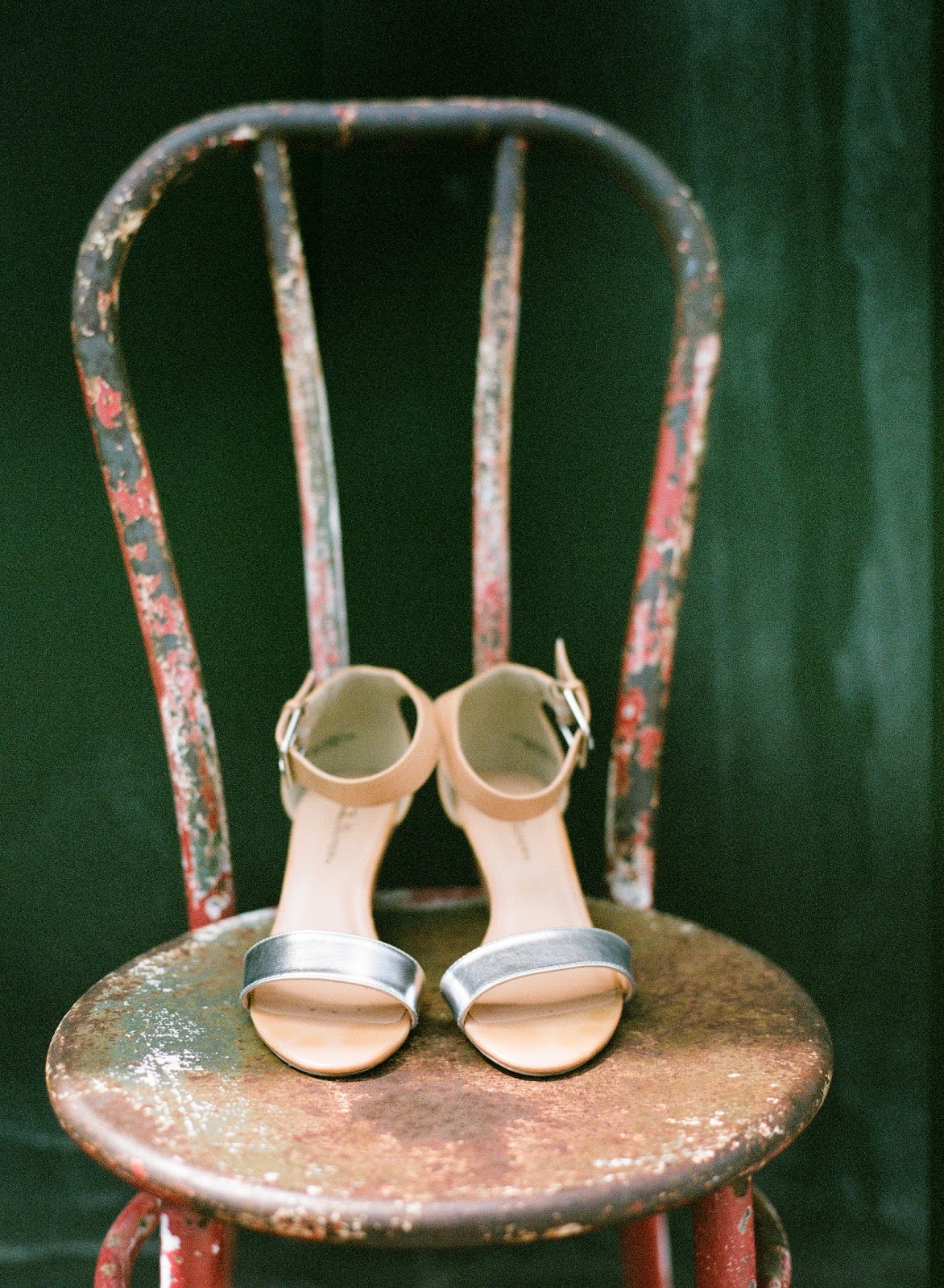 minimal silver wedding shoes on an antique chair with a green backdrop on a brooklyn, new york rooftop
