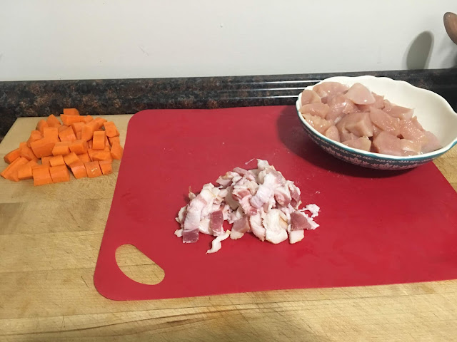 The carrots, bacon, and chicken diced on a cutting board.  
