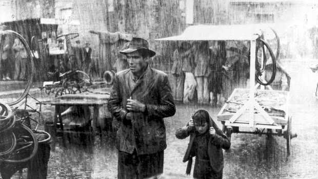 Fotograma de la película, Ladrón de bicicletas. Llueve en Roma, padre e hijo observan unas bicicletas