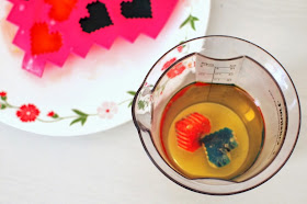place colored ice cubes in cooking oil