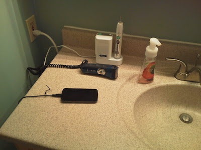 Three devices plugged into the power strip: electric toothbrush, electric razor, and cellphone.
