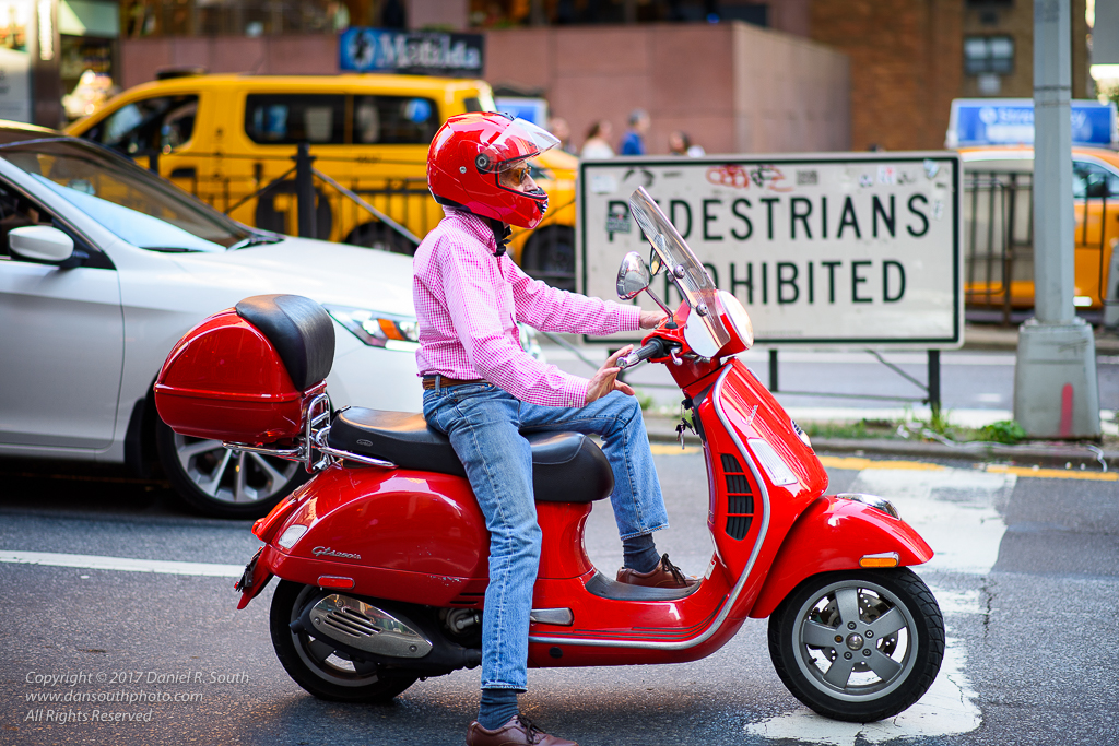 a photo of a bright red scooter in new york