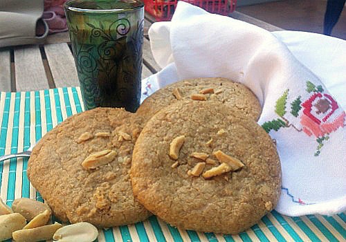 Unas galletas de cacahuetes grandecitas se presentan con cacahuetes por encima
