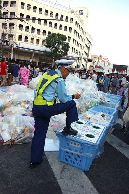 Japanese policeman guarding trash