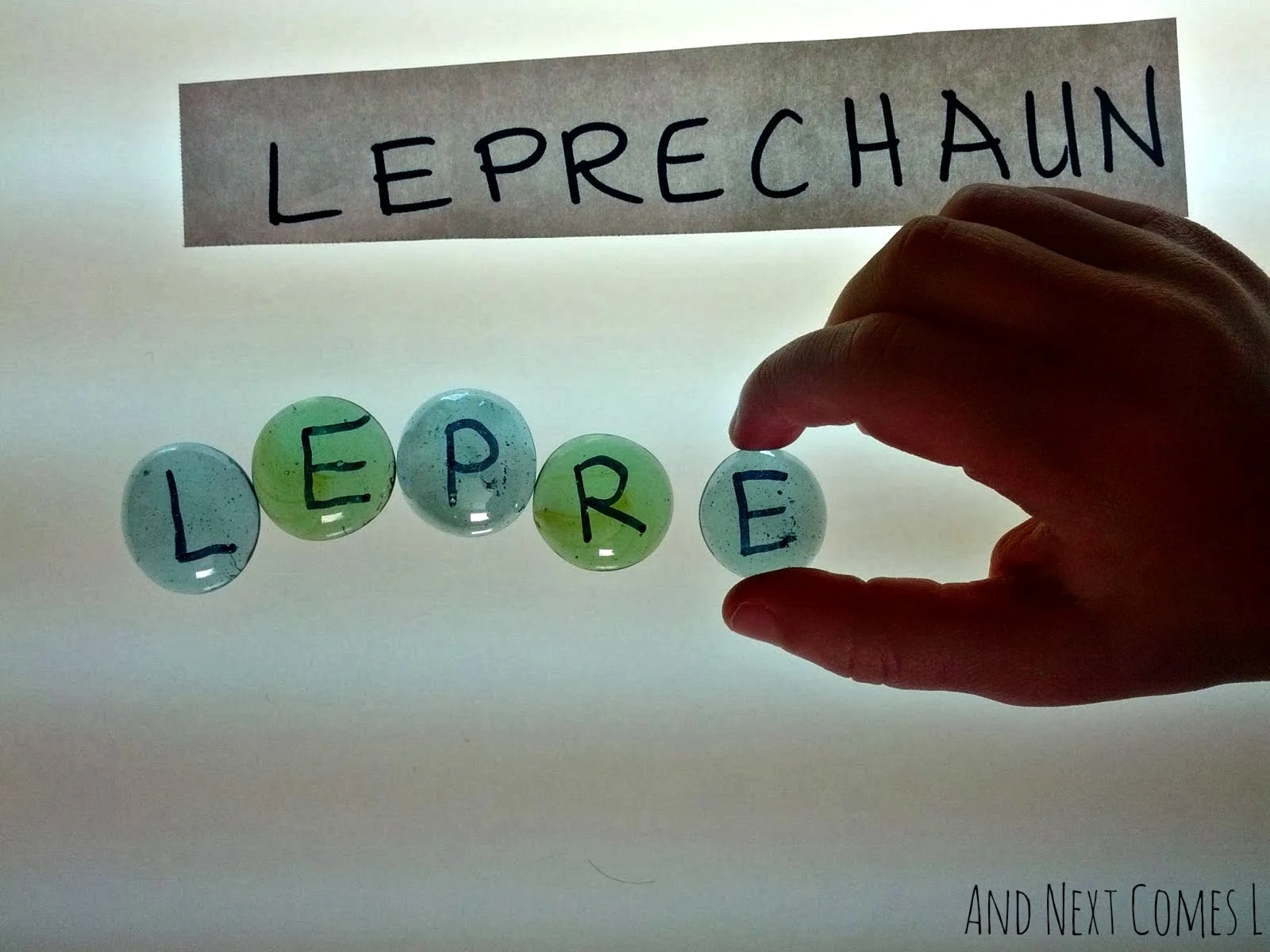Spelling with homemade alphabet stones on the light table from And Next Comes L