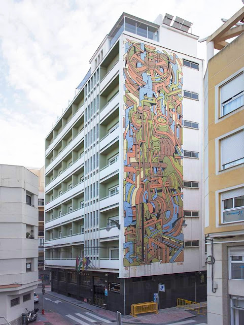 Aryz recently wrapped up his latest large mural, this time painted in the art district of Malaga for their ongoing MAUS Malaga project. Working on a 7 storey facade of the Bahia Malaga, Spanish artist created a new piece in his abstract series which he's been working on lately.