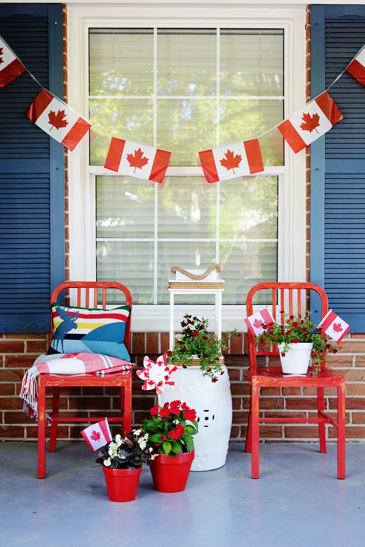 Canada Day porch decor with red metal chairs, plants, and flag bunting