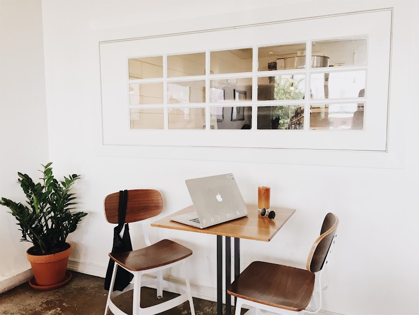 Macbook on Brown Wooden Dining Table and Chairs Macbook on Brown Wooden Dining Table and Chairs