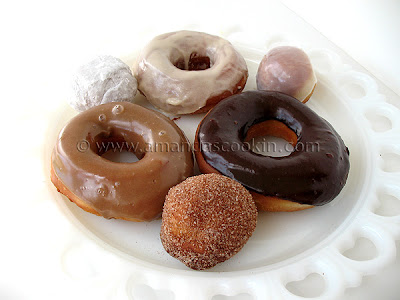 A photo of a plate of an assortment of homemade doughnuts.