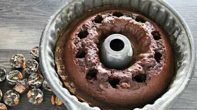 chocolate bundt cake with holes poked into it for peanut butter filling