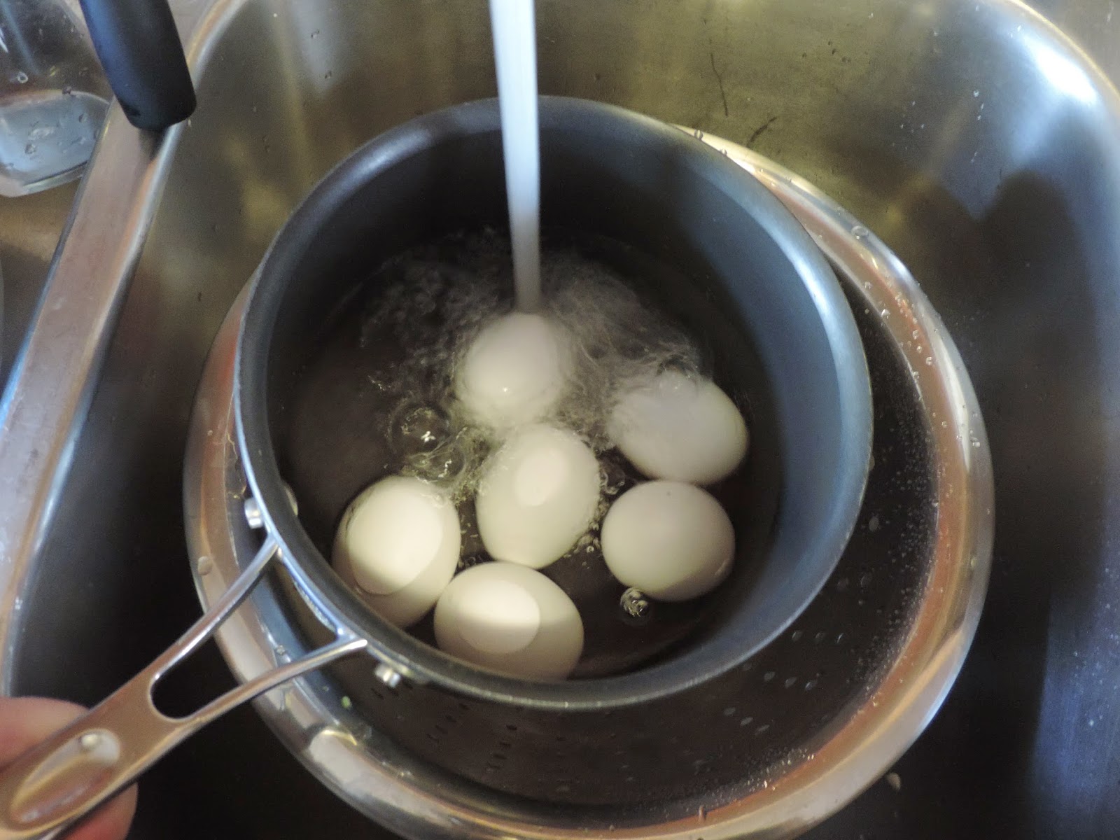 Water being added to the pot with the eggs in it. 