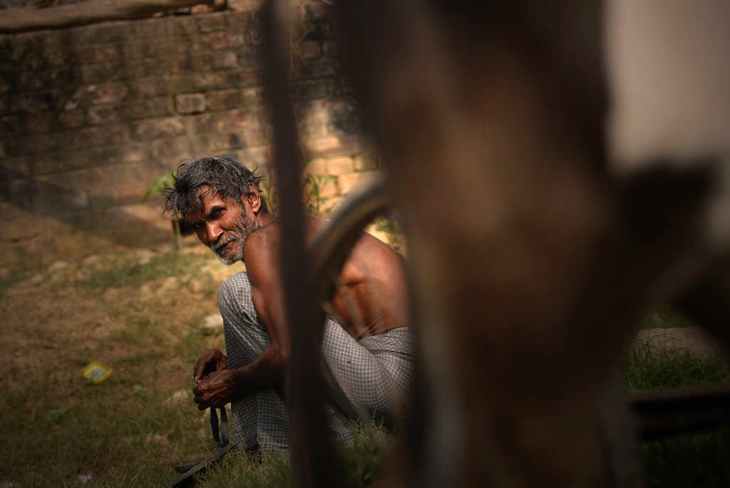 A local day worker preparing straps for a rickshaw in India