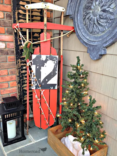 front door with lantern, sled and tree