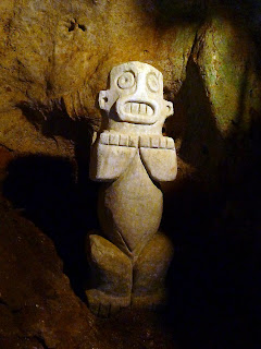 Statuette aus Stein in einer Höhle, wirkt wie afrikanische Kunst, stark stilisierte Person. Kuba, Baracoa, archäologisches Museum, Naturgeist Cemie, Statuette aus Stein.