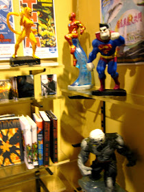 Interior view of a modern dolls' house miniature comic book shop, showing the metal shelving brackets
