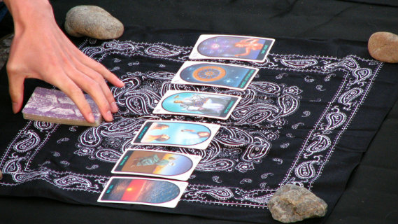 La main d'un interprète au dessus d'un tirage de tarot gratuit oui non
