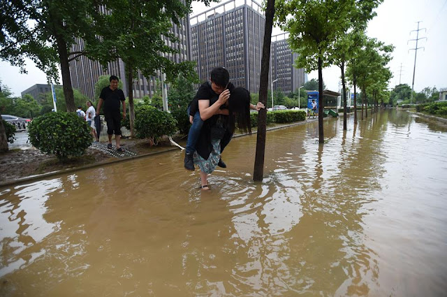 Woman Carries Her Boyfriend During Flood To Save His Leather Shoes From Soaking Woman Carries Her Boyfriend During Flood To Save His Leather Shoes From Soaking