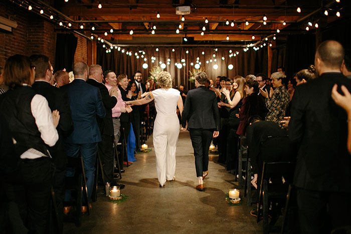 The brides walk down the aisle together in their same-sex wedding processional. Photo by Julie Harmsen. processional
