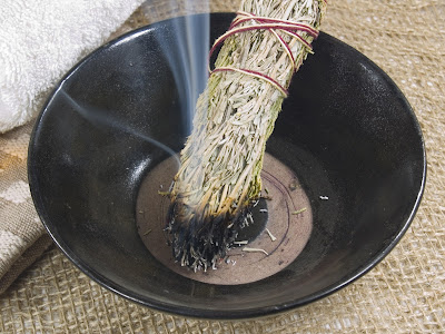bowl with burning sage smudge stick
