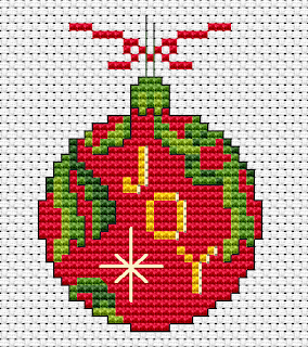 cross stitch of a festive ornament with the word &lsquo;joy&rsquo;