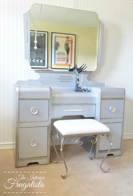 How to give a vintage waterfall vanity a drab to fab hollywood glam makeover with metallic paint, wrapping paper, and pearl embellished knobs.