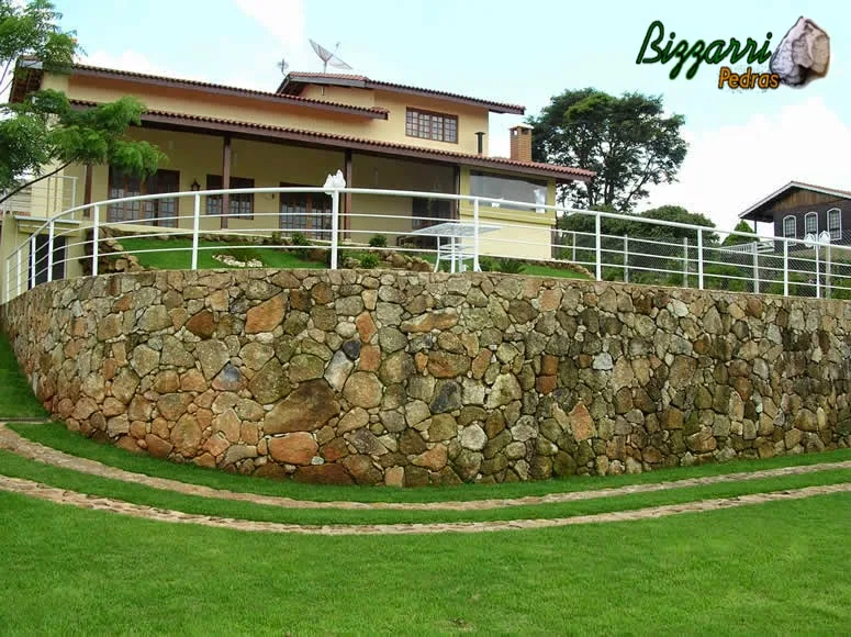 Calçamento de pedra rústica na entrada da residência com faixa de 70 cm de largura com a execução do muro de pedra rústica e construção da piscina com a construção da residência.