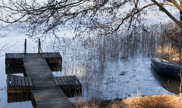 suomalainen järvimaisema laituri ja vene kevät