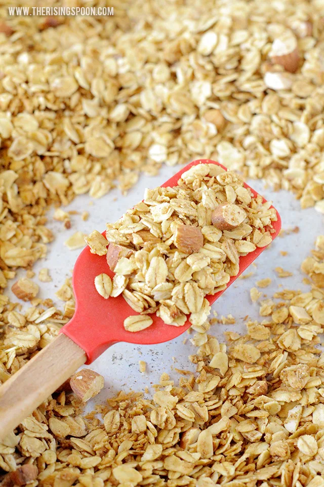 A healthy homemade granola recipe with coconut oil that's less sweet, but still packed with loads of flavor, crunch, and protein from homemade vanilla extract, real maple syrup, ground cinnamon, and chopped almonds. 