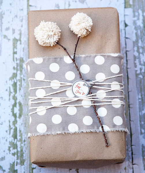 Envolver regalos con papel craft, pompon y tela.