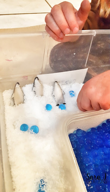 Snow sensory bin that uses fake snow is perfect for a preschool penguin sensory activity.