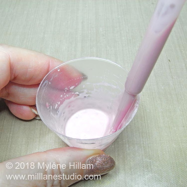 Graduated plastic measuring cup with leftover pink resin