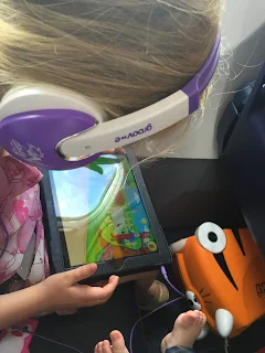 Young girl on iPad on an aeroplane