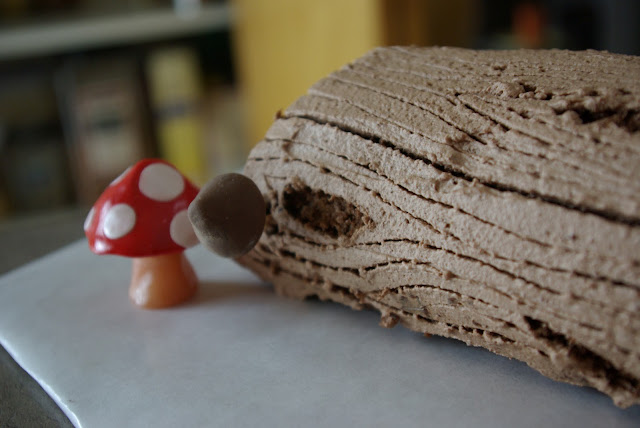 Log cake (Buche de Noel) with bark frosting, candy mushrooms, and edible moss