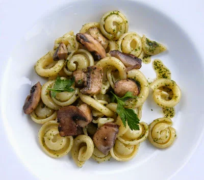 a bowl of mushroom pasta salad with a herby oil dressing