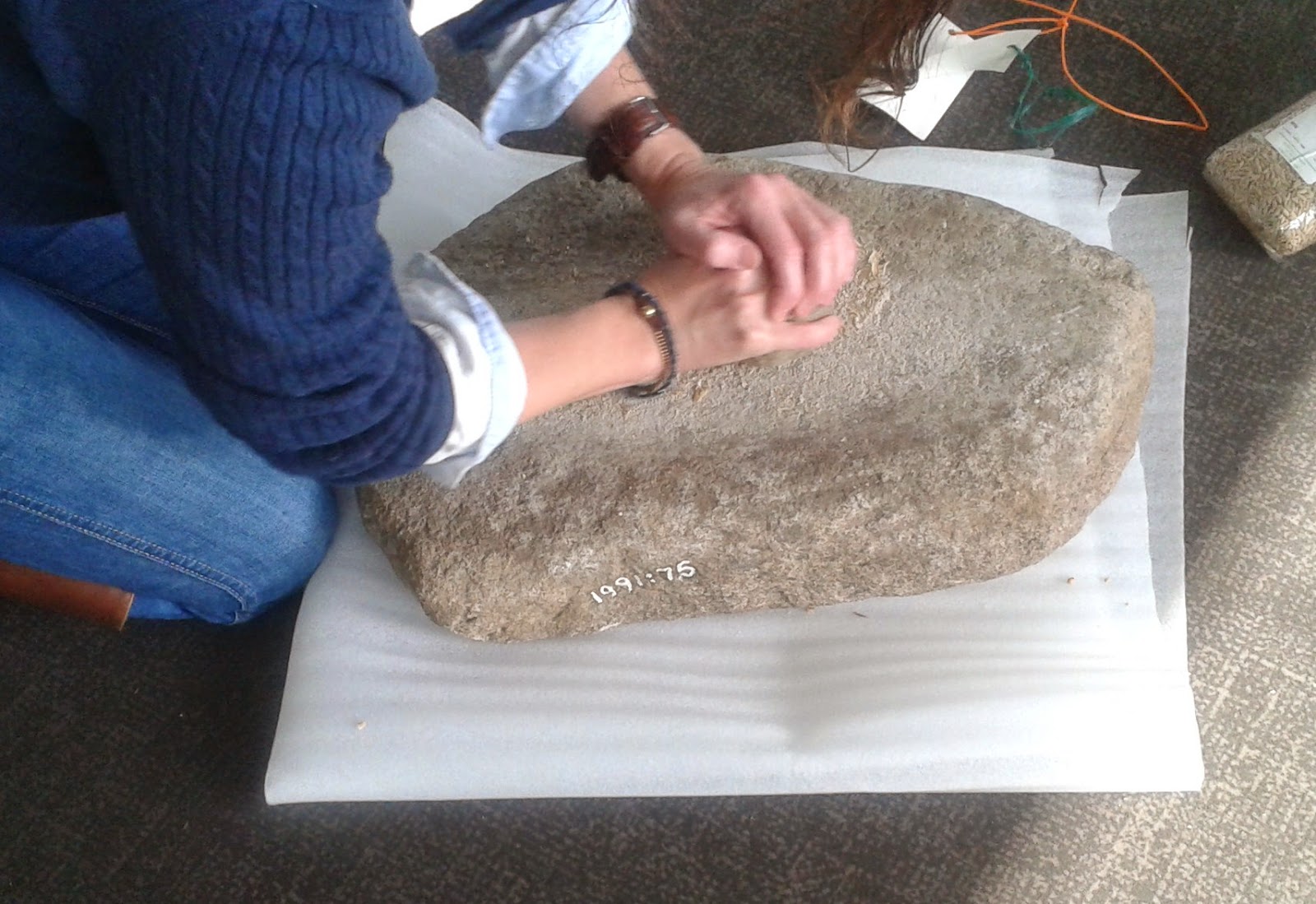 Grinding flour on an ancient quern stone