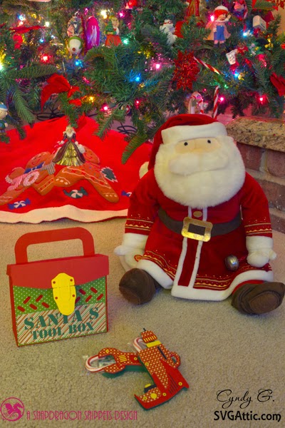Scene of a stuffed Santa sitting by the tree with his tool box and tools
