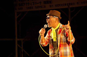 male vocalist, plaid jacket, yellow scarf, brown hat