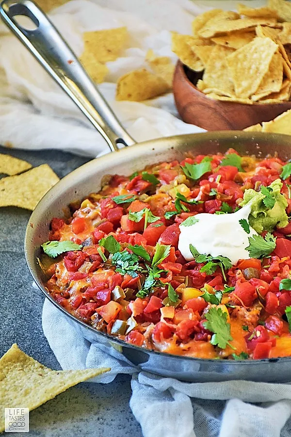 Hot Mexican Dip in a skillet with guacamole & sour cream