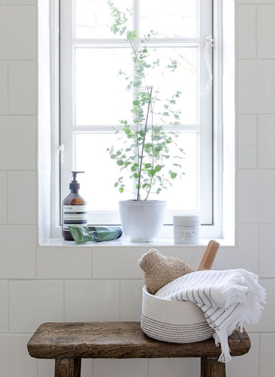Modern farmhouse style in rustic bathroom with white tile and wood stool by Tine K
