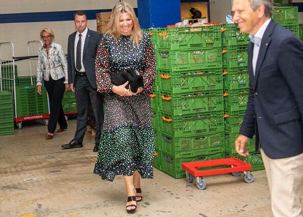 Queen Maxima wore a mixed ditsy floral tiered midi dress by Rixo. Gianvito Rossi shoes. She wore red earrings by Bodes and Bode