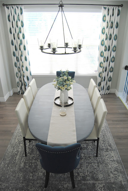 dining room, mix and match dining chairs, white decor, teal decor, aloof gray, curtain panels, drapes, curtains, faux floral, faux flowers, DIY, vintage rug, utah, table setting, tablescape, blue design, blue decor, teal, white, utah blogger, utah, blogger, chalk paint, painted dining table, painted furniture, how to hang curtains, how to style a dining room, best gray paint, favorite paint color, simple decorating, simple design, 8 chairs, 6 chairs, table that seats 8, captain chairs, dining room lighting, progress lighting, debut chandelier, six light chandelier, 6 light chandelier, black chandelier, exposed light bulbs, floating shelf, floating shelf dining room, minted art, water color art, water color painting, sunburst mirror, table runner, gray rug, safavieh rug, affordable design, design on a dime, laminate wood floors, flooring, cheap flooring, cheap hardwood, hardwood, laminate hardwood, wood stair treads, white risers, stairs, wood stairs, laminate stairs, colorful design, white dining chair, white chairs, modern design, traditional design, gray flooring, gray laminate, gray hardwood, gray stain, gallery wall